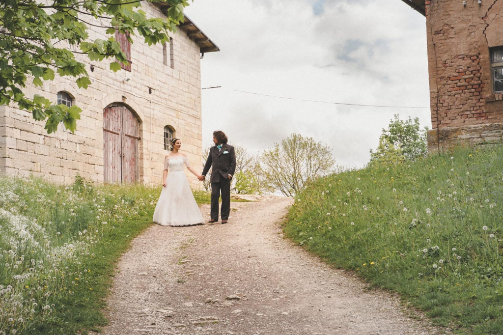 Auf dem Weg zum Burgtor von Burg Lohra schauen sich Braut und Bräutigam an und genießen den intimen, ruhigen Moment zu zweit