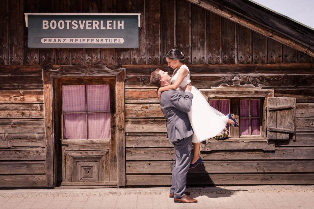 Der Bräutigam hebt seine Braut für dieses Hochzeitsfoto in Rottach-Egern am Tegernsee