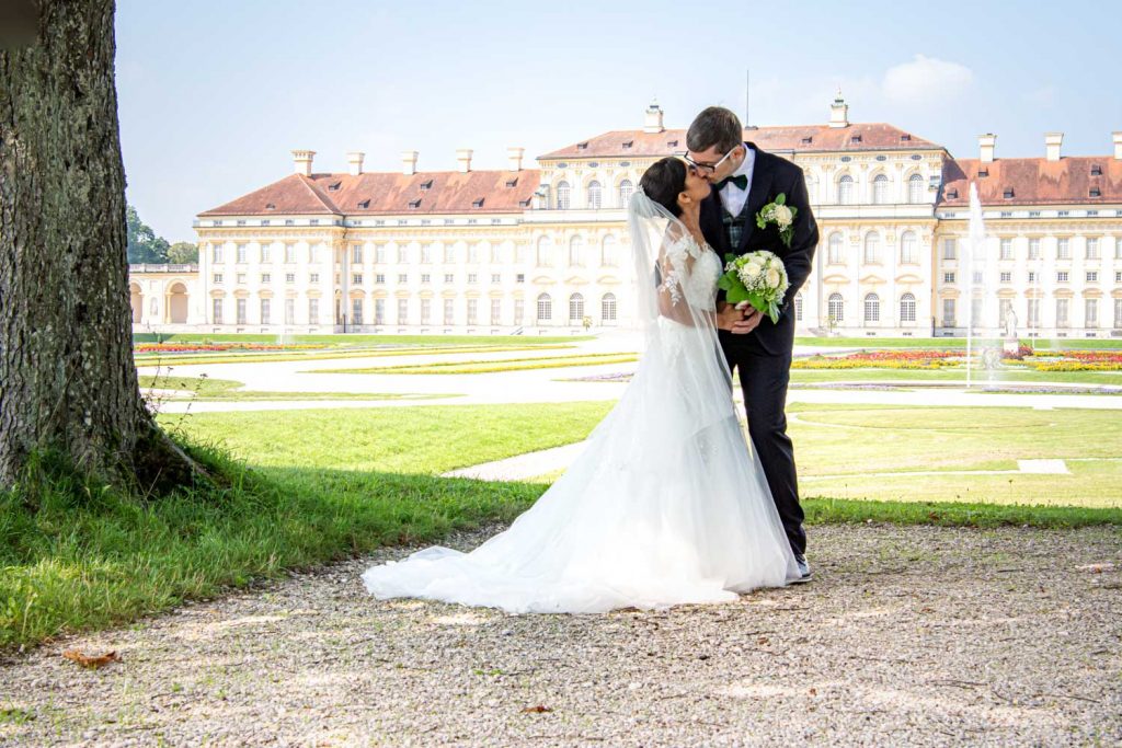 Das Brautpaar küsst sich im Park des Schleißheimer Schlosses