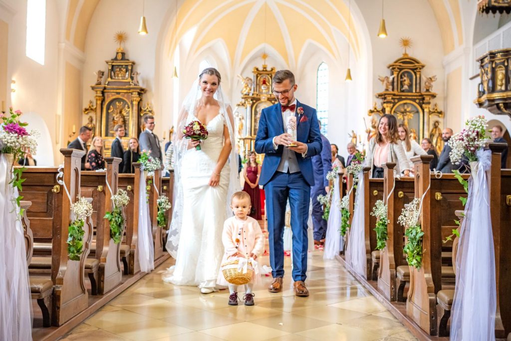 Hochzeitsfotograf München macht ein Hochzeitsfoto von dem Brautpaar beim Auszug aus der Kirche nach der Hochzeit in Feldkirchen bei München.