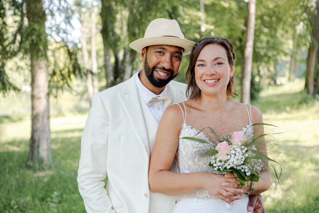 Das glückliche Brautpaar strahlt in die Kamera der Hochzeitsfotografin.