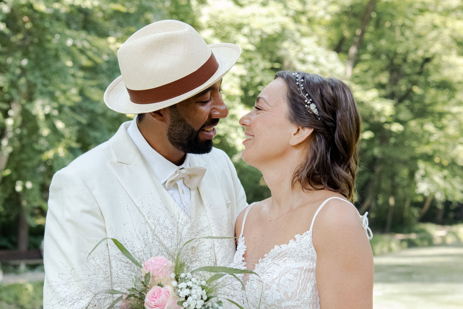 Das Brautpaar strahlt nach dem First Look vor der Hochzeit an der Isar