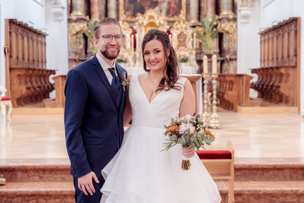 Hochzeitsfotograf hält das Paar vor dem barocken Altar des Kloster Scheyern fest.