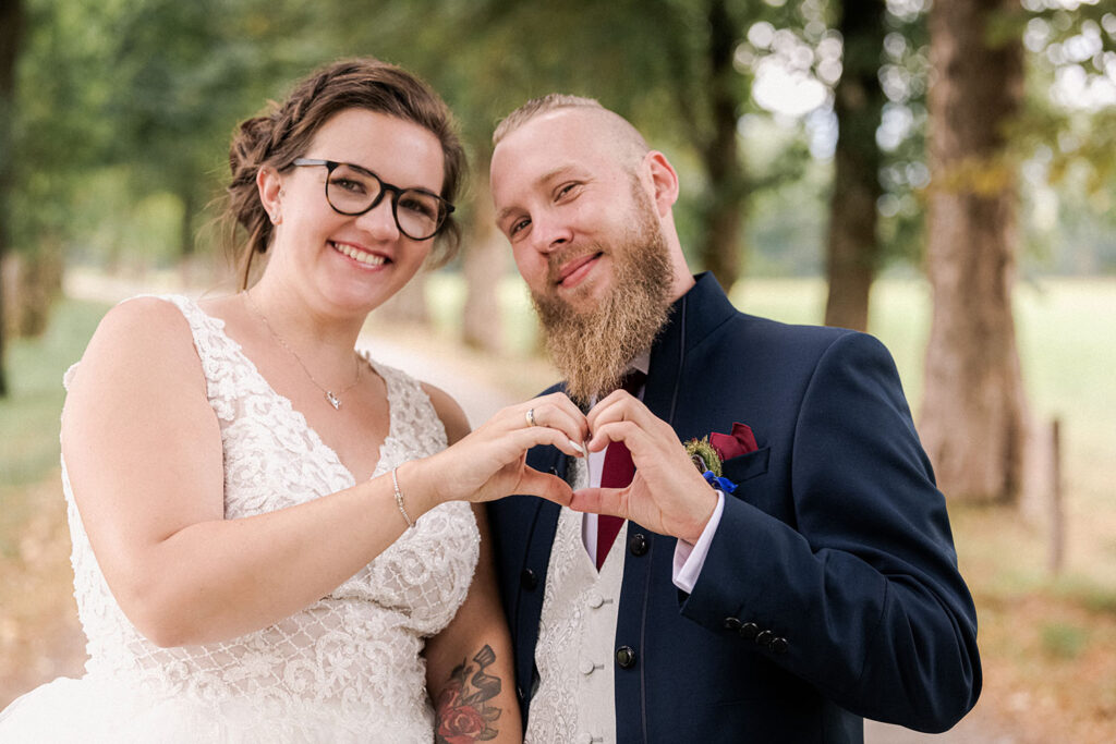 Mit ihren Händen formt das Brautpaar ein Herz - der perfekte Motiv für die Danksagungskarten der Hochzeit in der Eventscheune Wallenburg