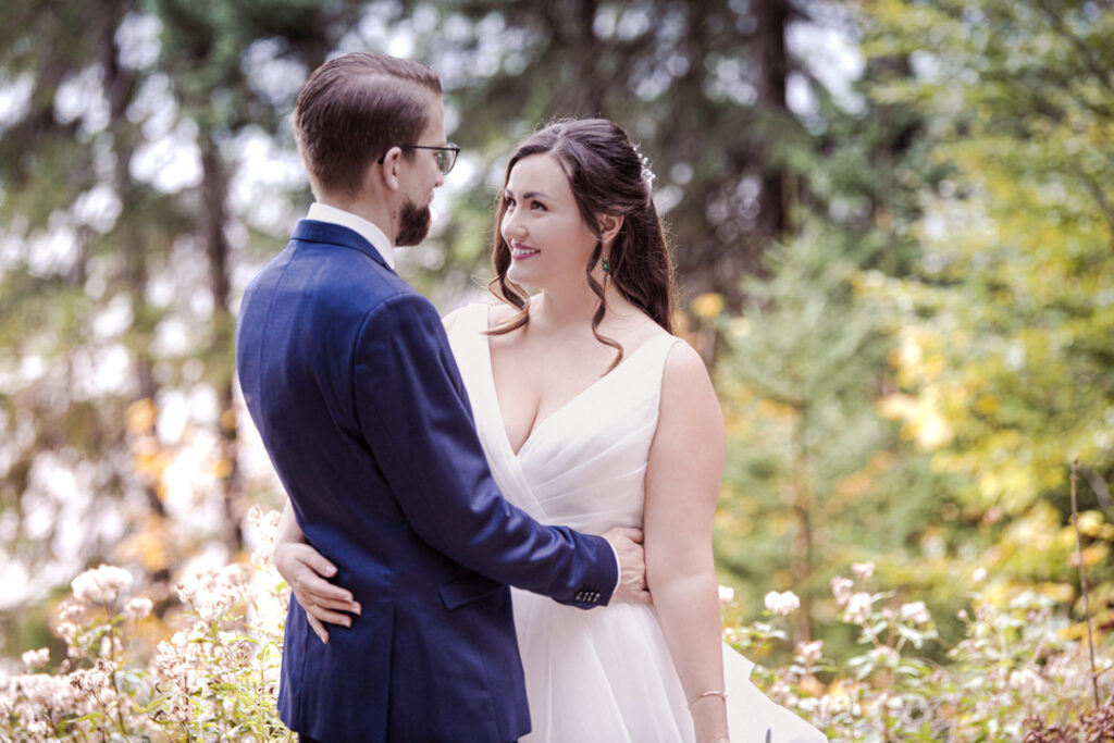Der Hochzeitsfotograf fotografiert das Paar in den Alpen am Eibsee beim After-Wedding-Shooting im Gegenlicht.