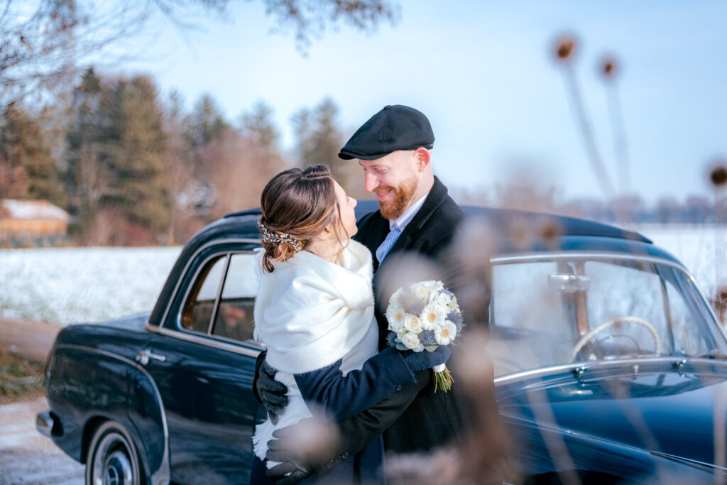 Glückliches Brautpaar während ihrer zauberhaften Winterhochzeit im Schnee.